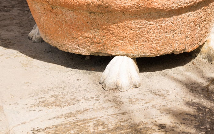 Pot feet supporting a terracotta garden pot for summer plants