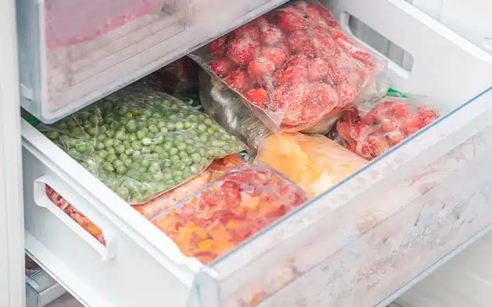 frozen vegetables and fruits bagged in freezer drawer